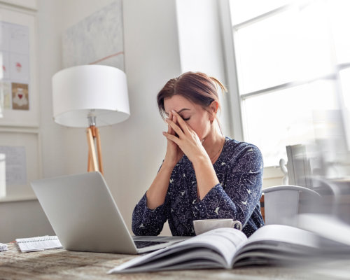 Frau sitzt gestresst vor dem Laptop